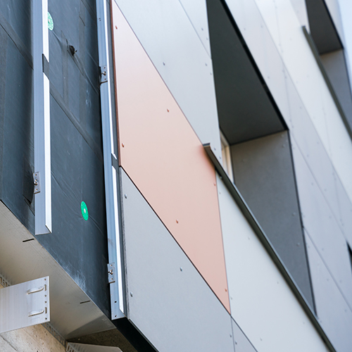 Cladding boards being installed on a building facade